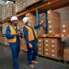 Dos trabajadores realizando un plan de formación en una fábrica de cartón.